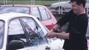 A demonstration of a thief breaking into a car by a police officer and a decoy car in Harlow, Essex, England