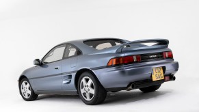 A light-blue 1992 Toyota MR2 parked in a white room