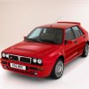 A red 1993 Lancia Delta Integrale hatchback in a white photo studio