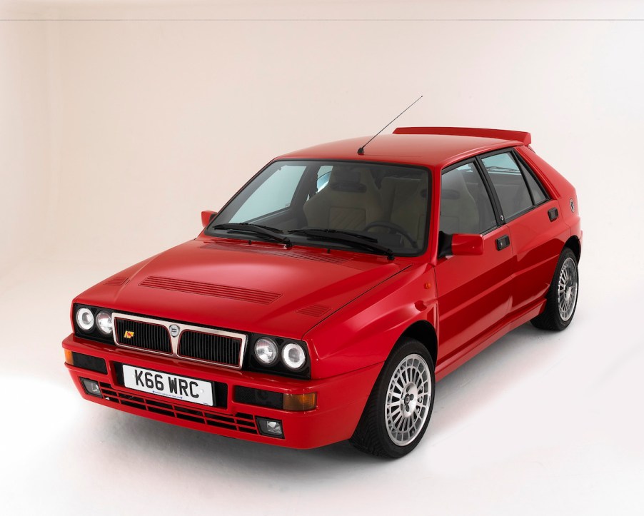 A red 1993 Lancia Delta Integrale hatchback in a white photo studio