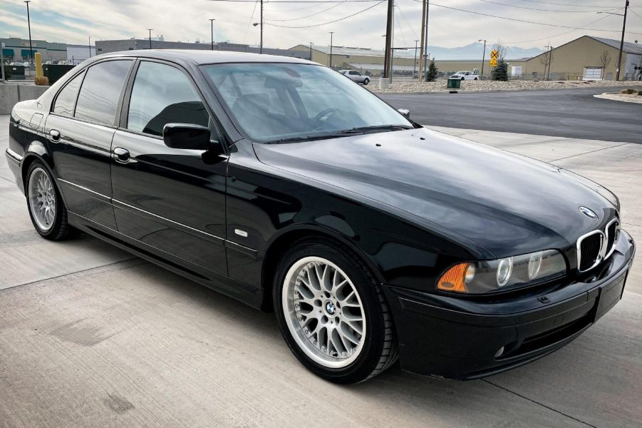 A black 2003 E39 BMW 530i with Sport Package on a parking garage roof