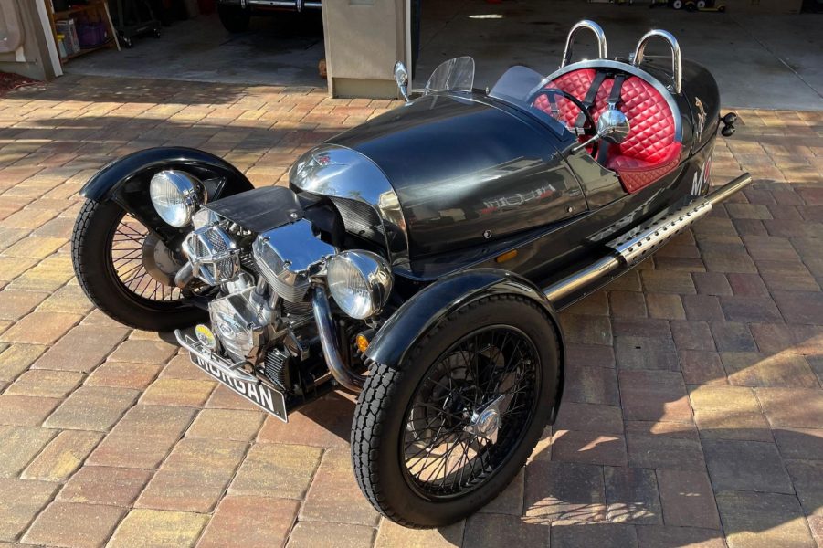 A black 2012 Morgan 3-Wheeler with a quiled-red-leather cabin