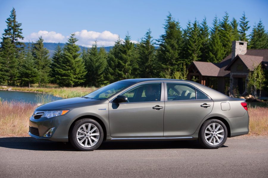 A profile view of a brown 2012 Toyota Camry Hybrid Sedan.