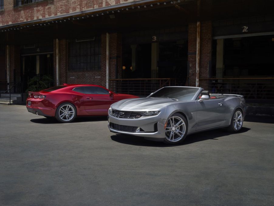 2021 Chevrolet Camaro LS and LT models in red and silver parked outside of a brick building