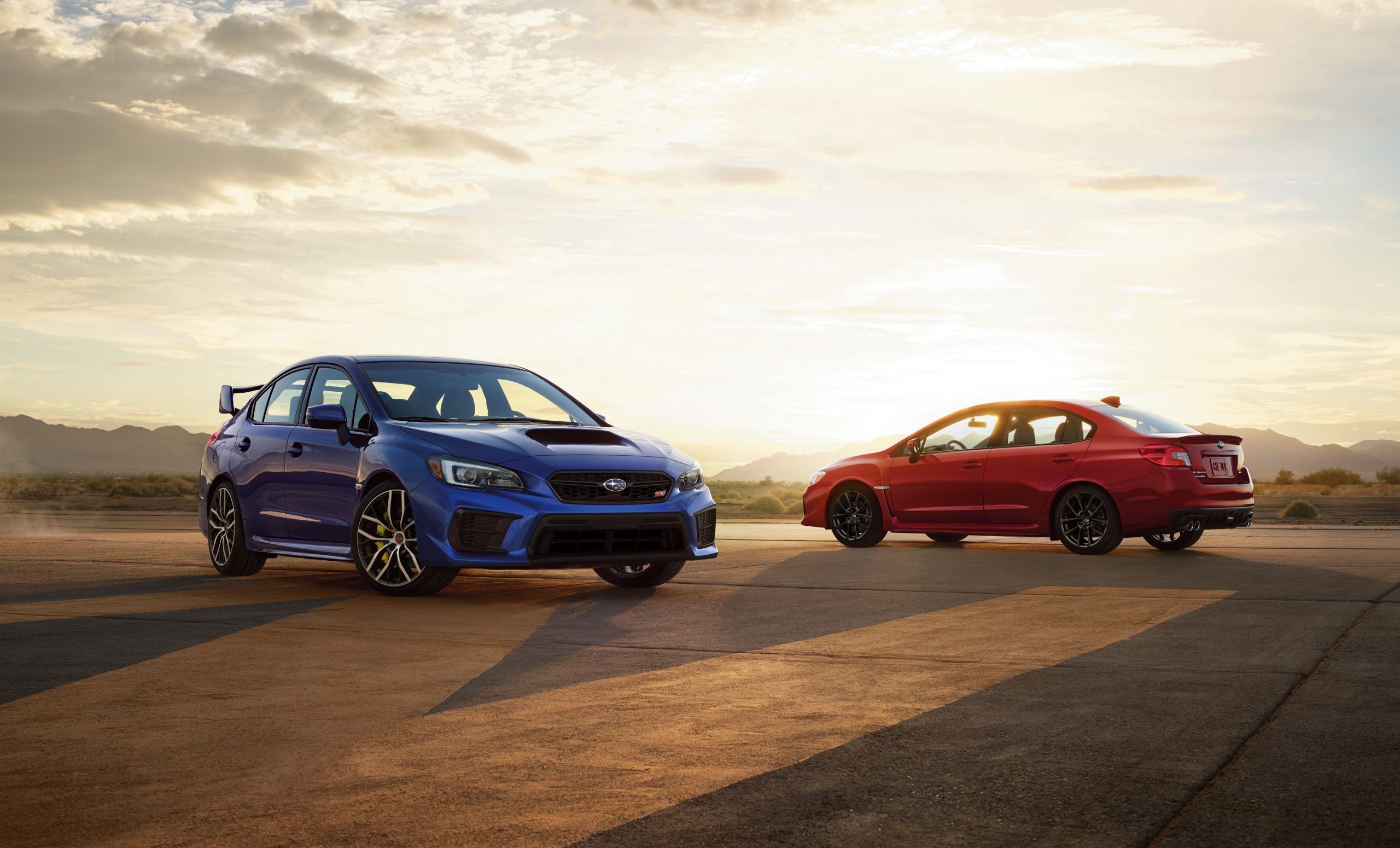 A pair of Subaru WRX models shot at sunset