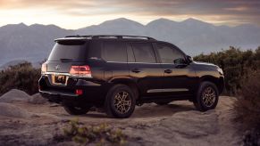 2021 Toyota Land Cruiser full-size off-road SUV model parked on top of a hill in a desert mountain range