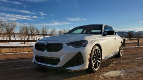 A white 2022 BMW M240i xDrive shot from the front 3/4 on a dirt road