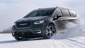 A black 2022 Chrysler Pacifica is driving in snow.