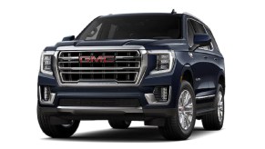 A dark blue 2022 GMC Yukon against a white background.