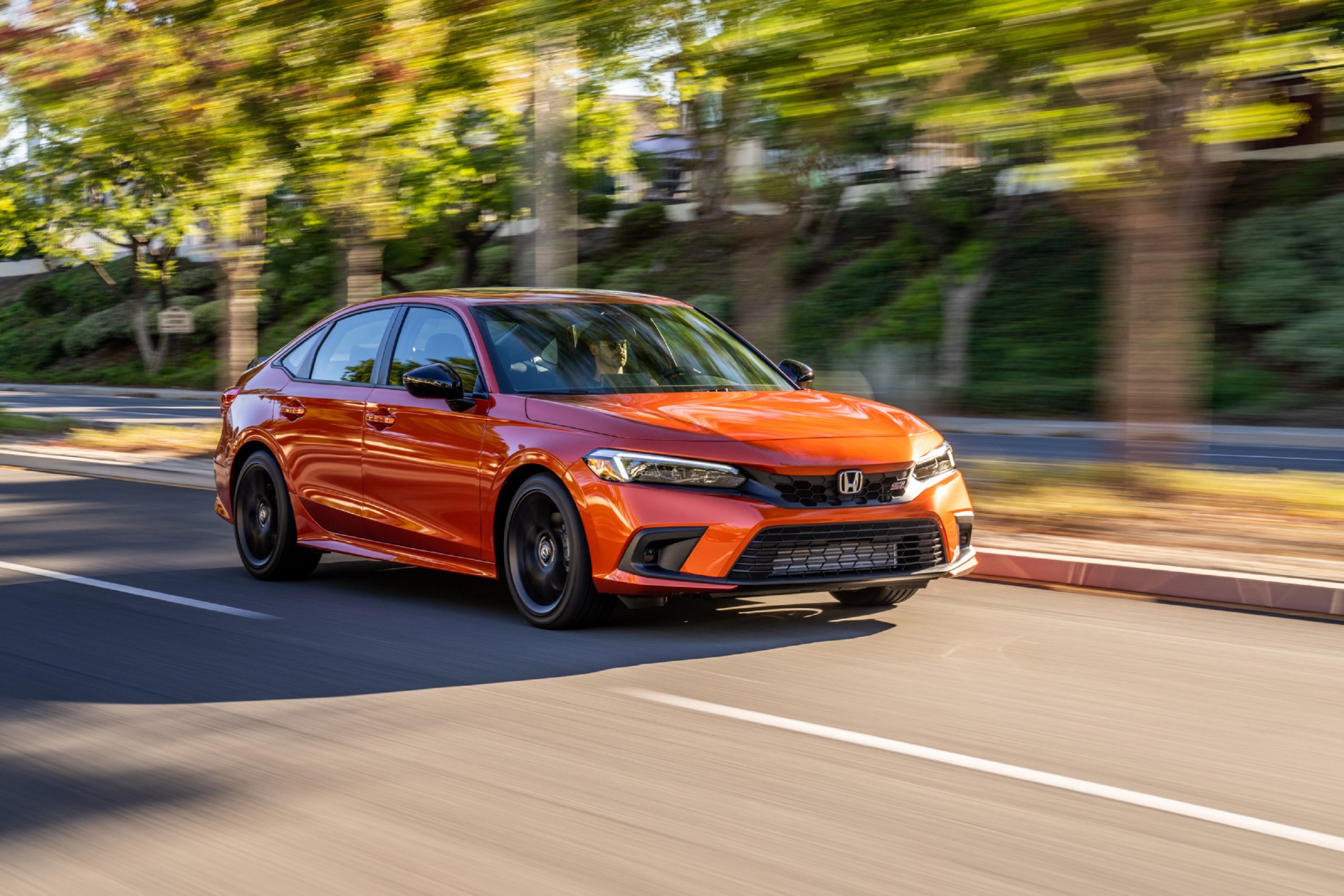 An orange 2022 Honda Civic Si shot on a city street