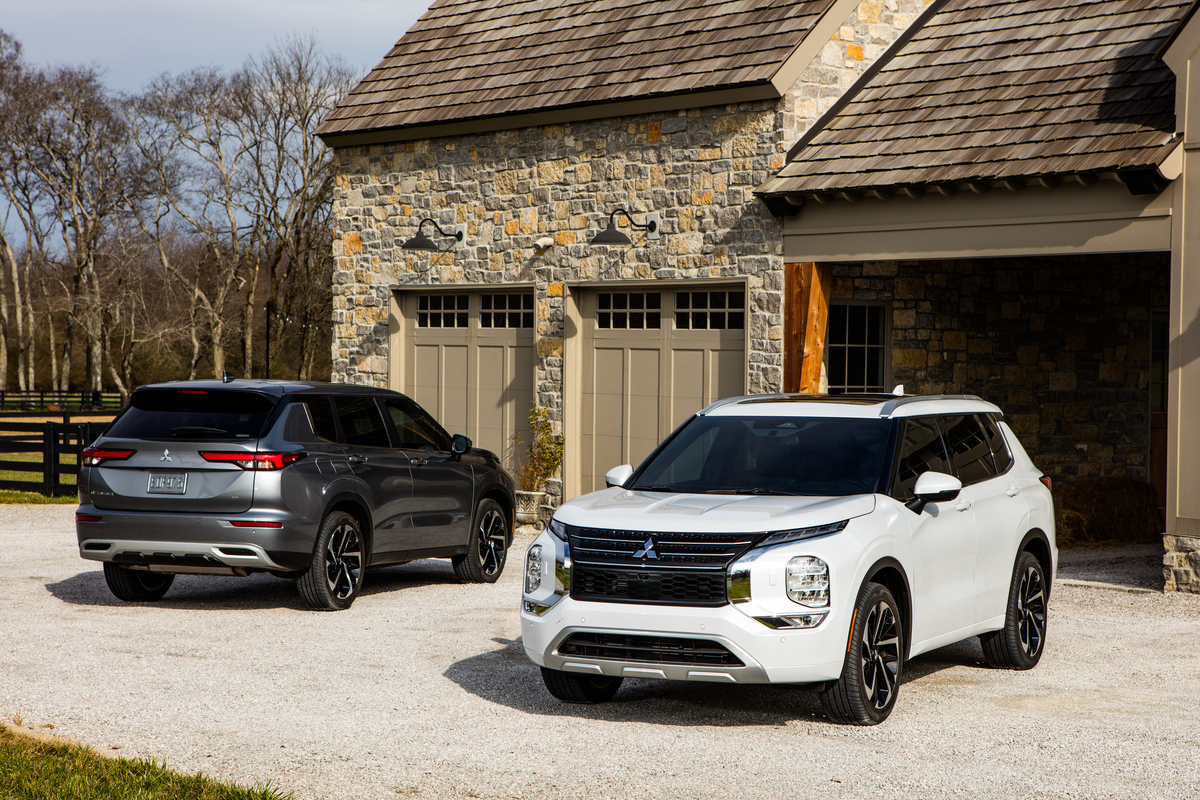 2022 Mitsubishi Outlander SUVs parked in a large rustic home's driveway