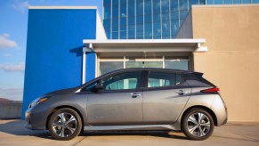 A 2022 Nissan Leaf parked outside a glass building on a sunny day