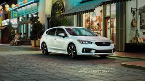 A white 2022 Subaru Impreza wagon shot from the front 3/4 at night