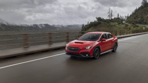 A red 2022 Subaru WRX sedan shot from the front 3/4 on a rainy day