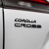 The 2022 Toyota Corolla Cross compact crossover SUV with Wind Chill Pearl paint color option and showing its model badging