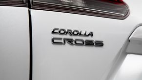 The 2022 Toyota Corolla Cross compact crossover SUV with Wind Chill Pearl paint color option and showing its model badging