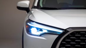 A white 2022 Toyota Corolla Cross SUV's right grille, headlight, and side mirror