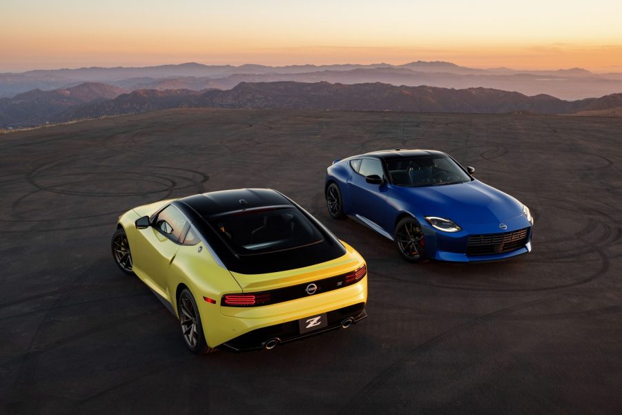 A pair of 2023 Nissan Z cars in yellow and blue shot on the a cliffside at sunset