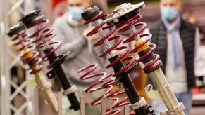 Aftermarket gold-and-silver and black-and-silver shock absorbers and red springs on display