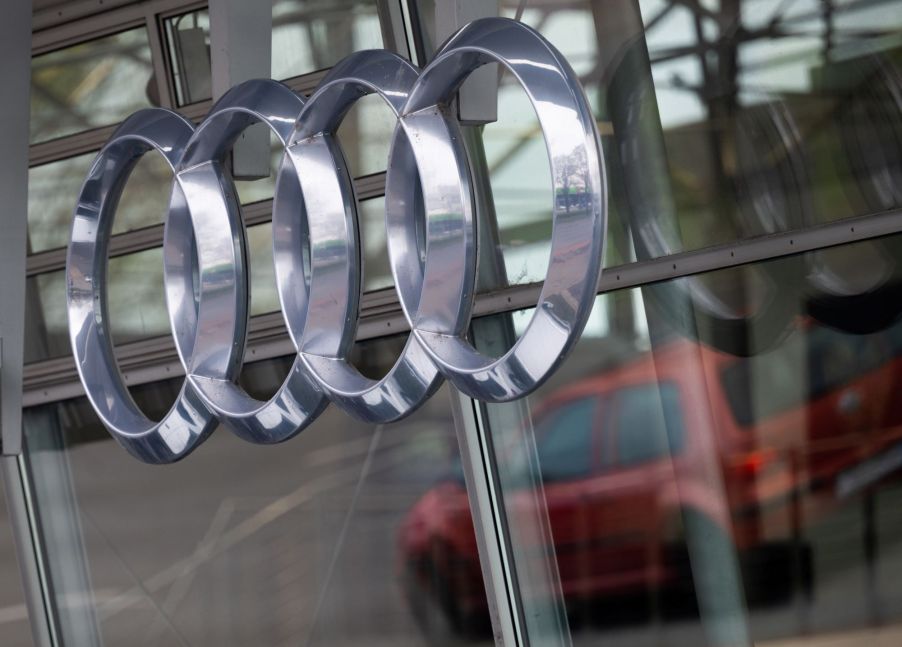 A chrome Audi logo on a glass background.