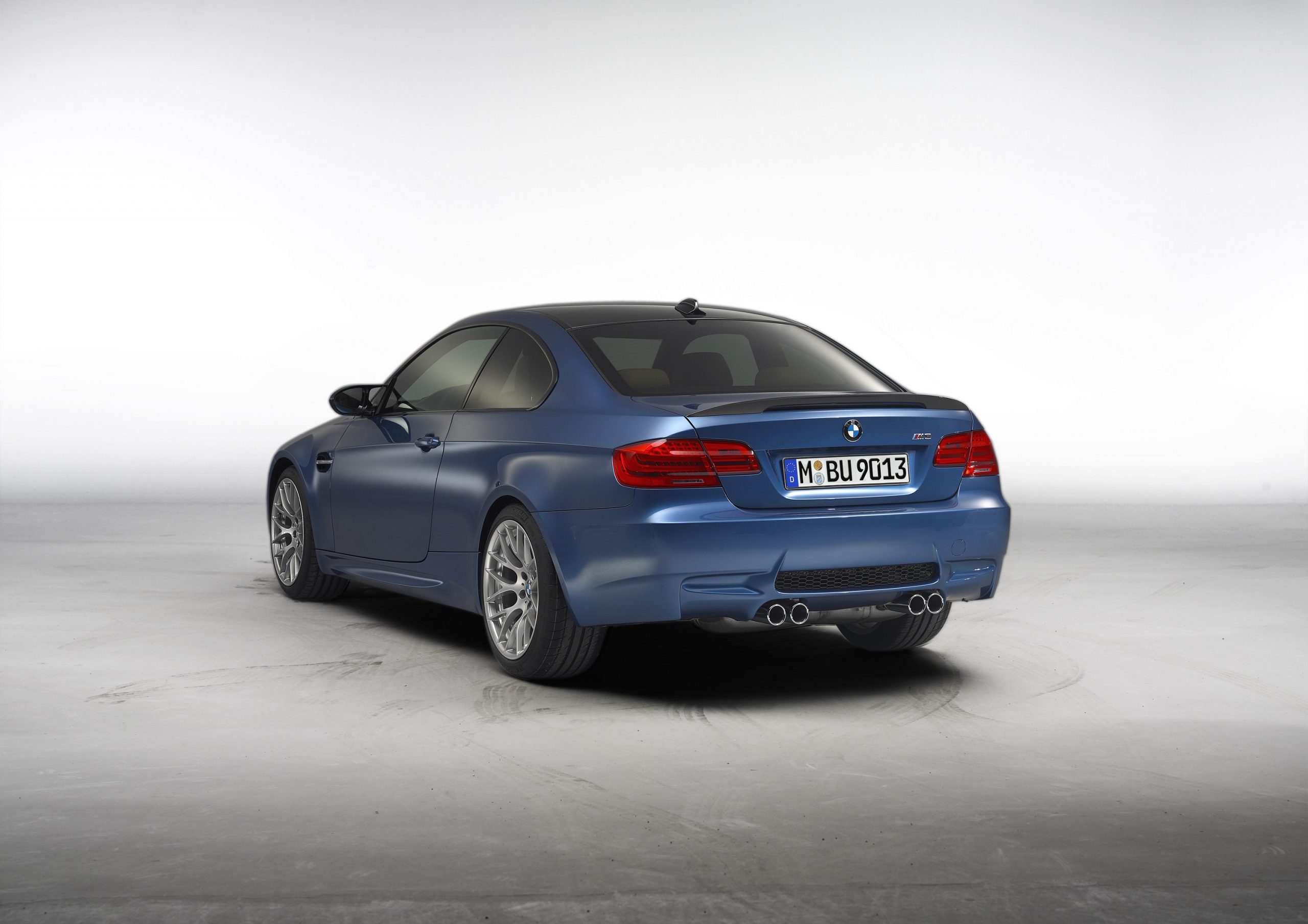 A rear 3/4 shot of a blue M3 sports car shot in a photo studio