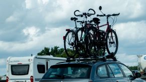 A BMW car driving on a highway with bike rack on top