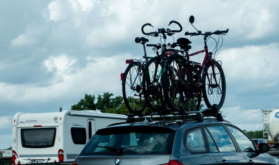 A BMW car driving on a highway with bike rack on top