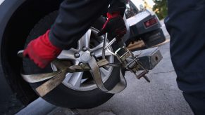 A car repossession occurring by strapping straps to the tires.