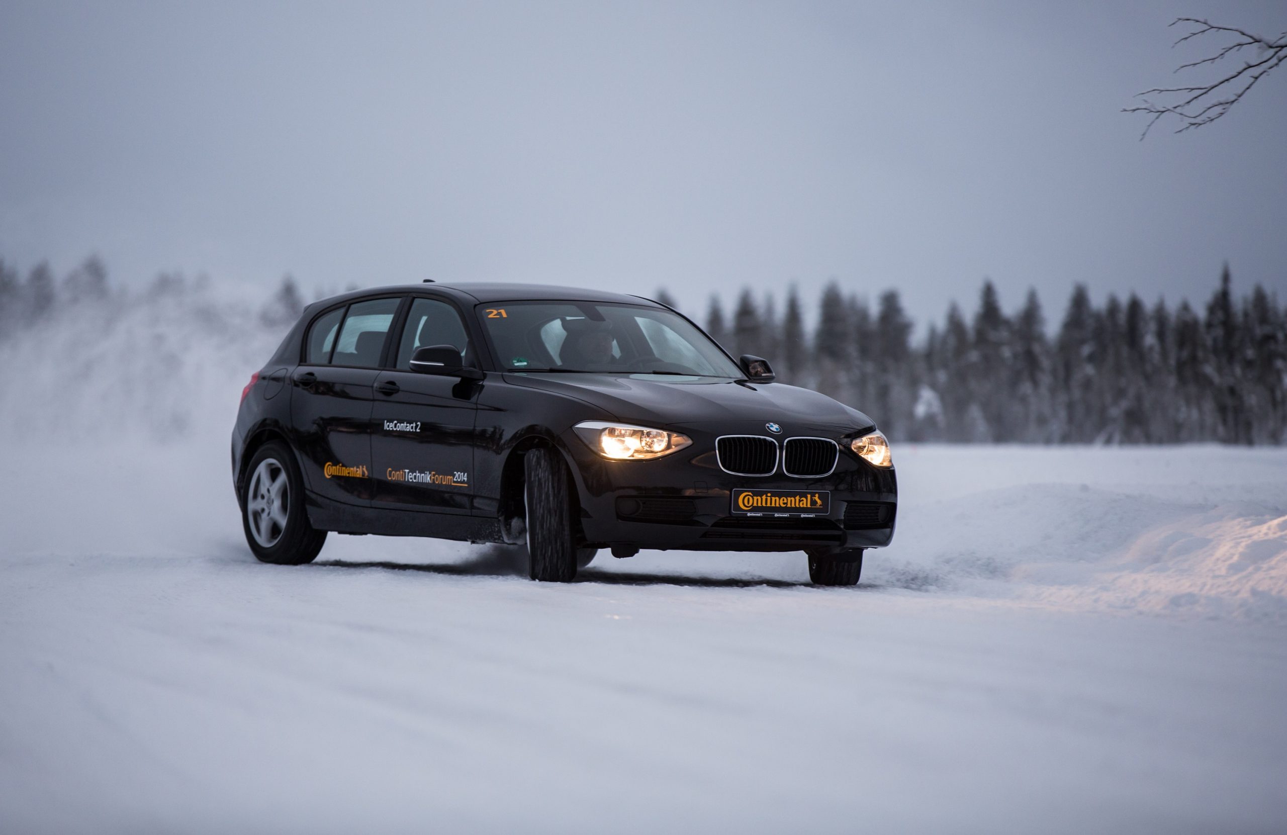 A car equipped with winter tires drifts on a frozen lake bed