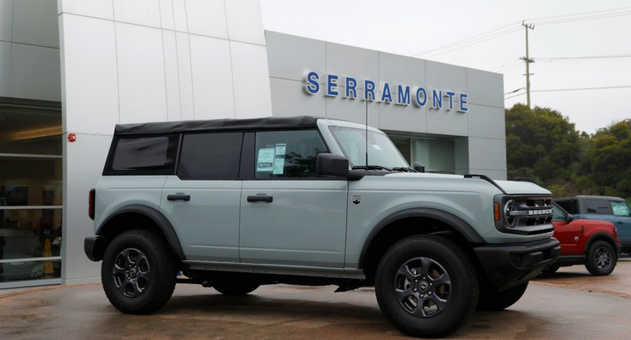 A gray Ford Bronco is parked outside of a dealership.