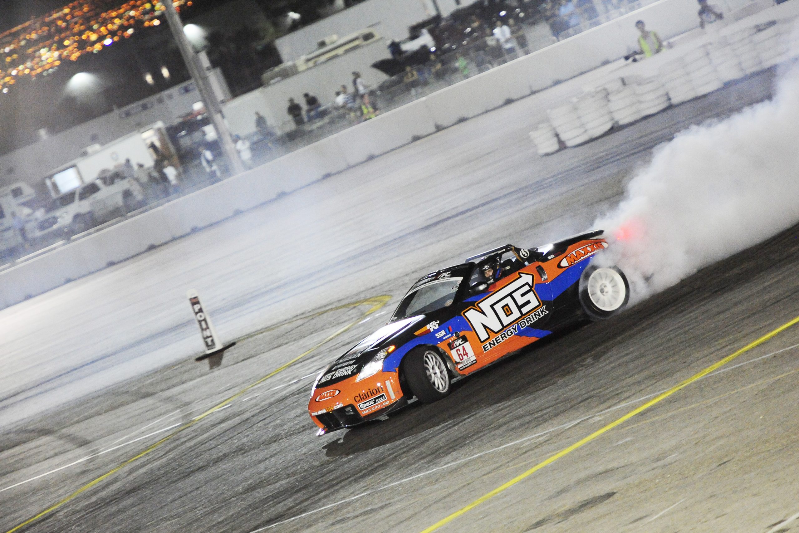 A RWD Nissan 370Z slides through a corner on a race track