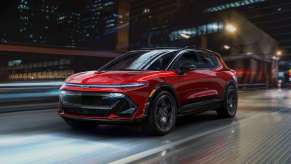 Front view of red 2024 Chevy Equinox EV driving across a bridge