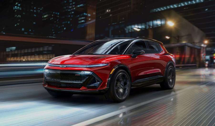 Front view of red 2024 Chevy Equinox EV driving across a bridge