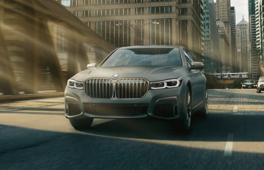 Fully loaded new gray 2022 BMW 7 Series M760i xDrive Sedan driving across a bridge