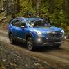 Geyser Blue 2022 Subaru Forester driving on a dirt road