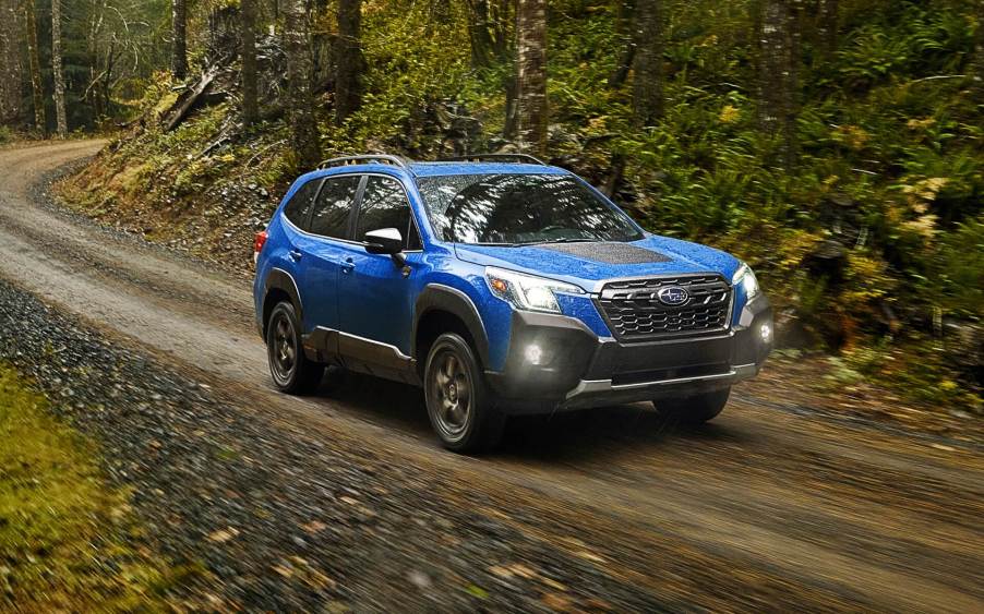 Geyser Blue 2022 Subaru Forester driving on a dirt road