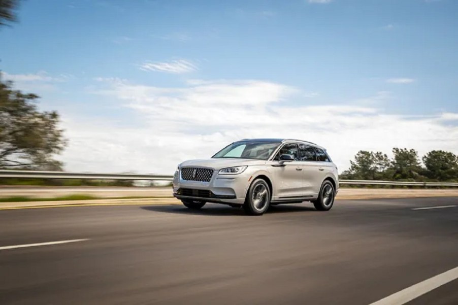 A white 2021 Lincoln Corsair Grand Touring driving down a road.