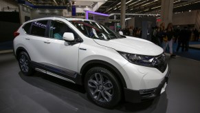 A white Honda CR-V Hybrid is on display.