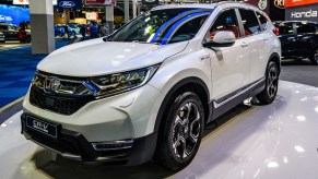 A white Honda CR-V Hybrid is on display.