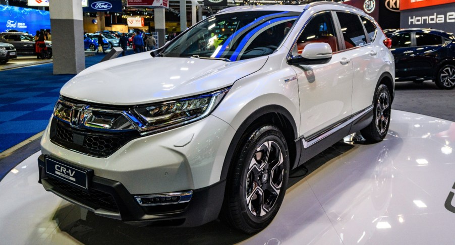 A white Honda CR-V Hybrid is on display.