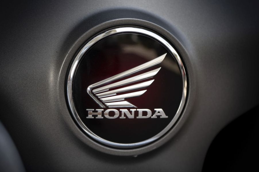 Honda motorsports logo in black and silver on a grey background.