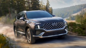 A black 2022 Hyundai Santa Fe Hybrid is driving off-road.