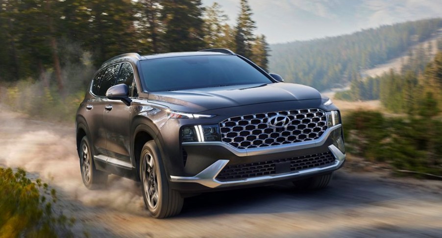 A black 2022 Hyundai Santa Fe Hybrid is driving off-road.