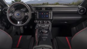 The black-and-red seats and black dashboard of a new 2022 Subaru BRZ sports car with a manual transmission