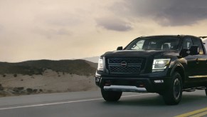 A black 2021 Nissan Titan driving down a road.