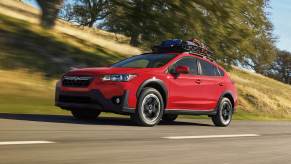 Pure Red 2022 Subaru Crosstrek driving by a hill