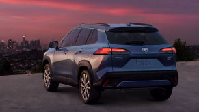 Rear view of Blue Crush Metallic 2022 Toyota Corolla Cross with a city skyline in the background