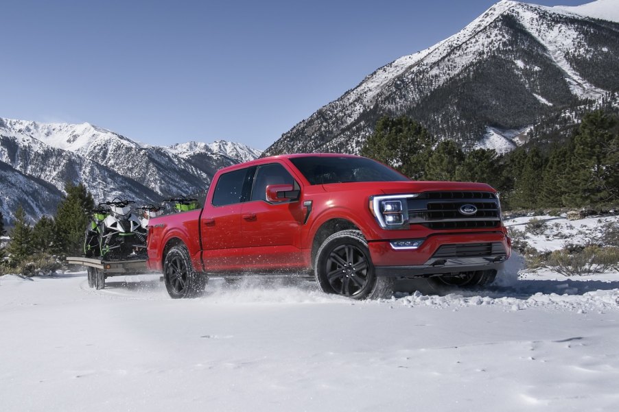 Red 2021 Ford F-150, which offers a deal to save money in Winter 2022, according to U.S. News, driving through snow