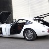 The rear 3/4 view of a white Rocky Auto Toyota 2000GT replica with its doors and panels open