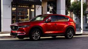 Soul Red Crystal Metallic 2022 Mazda CX-5 parked next to a sidewalk